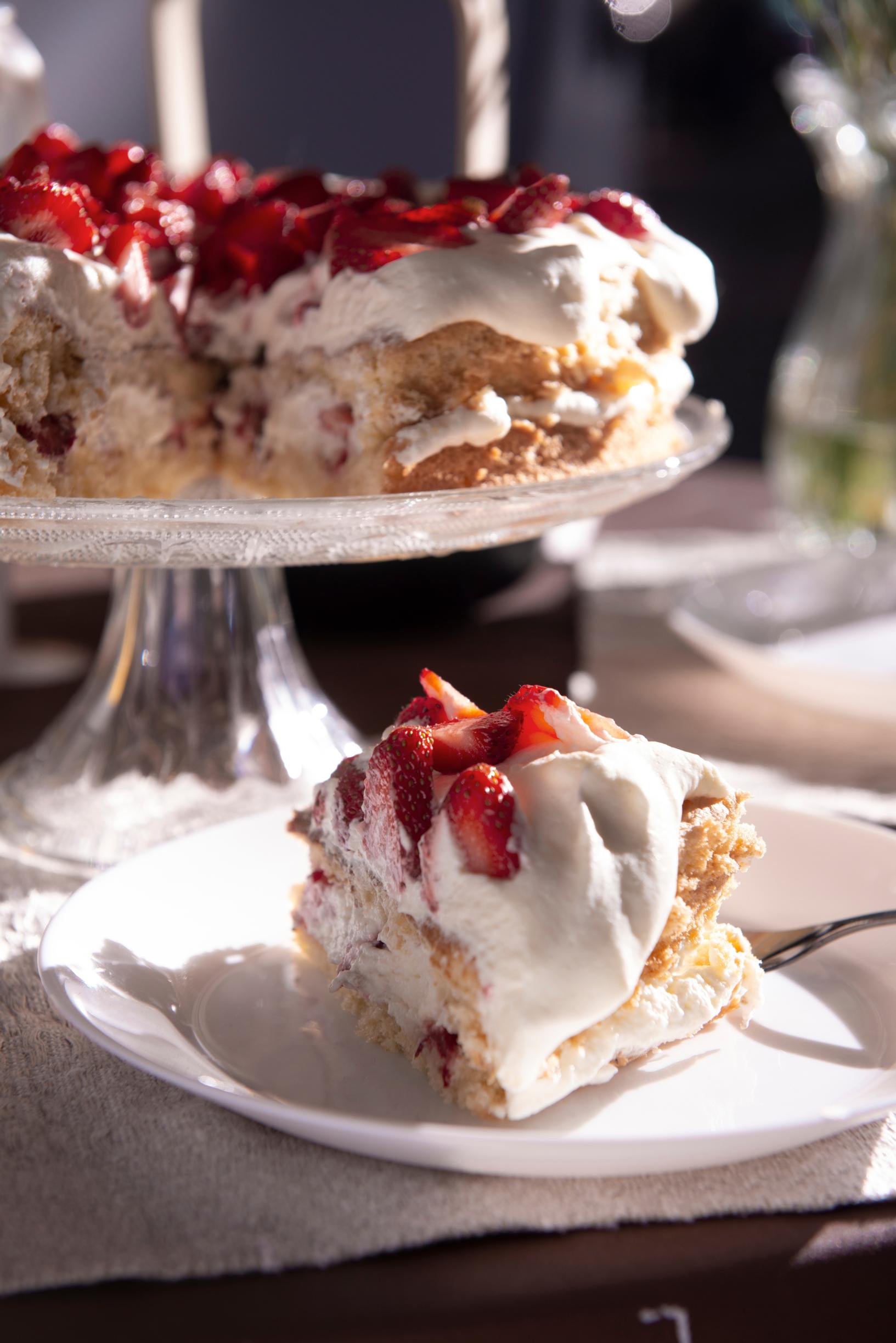 strawberry cake on a stand with a slice on a plate