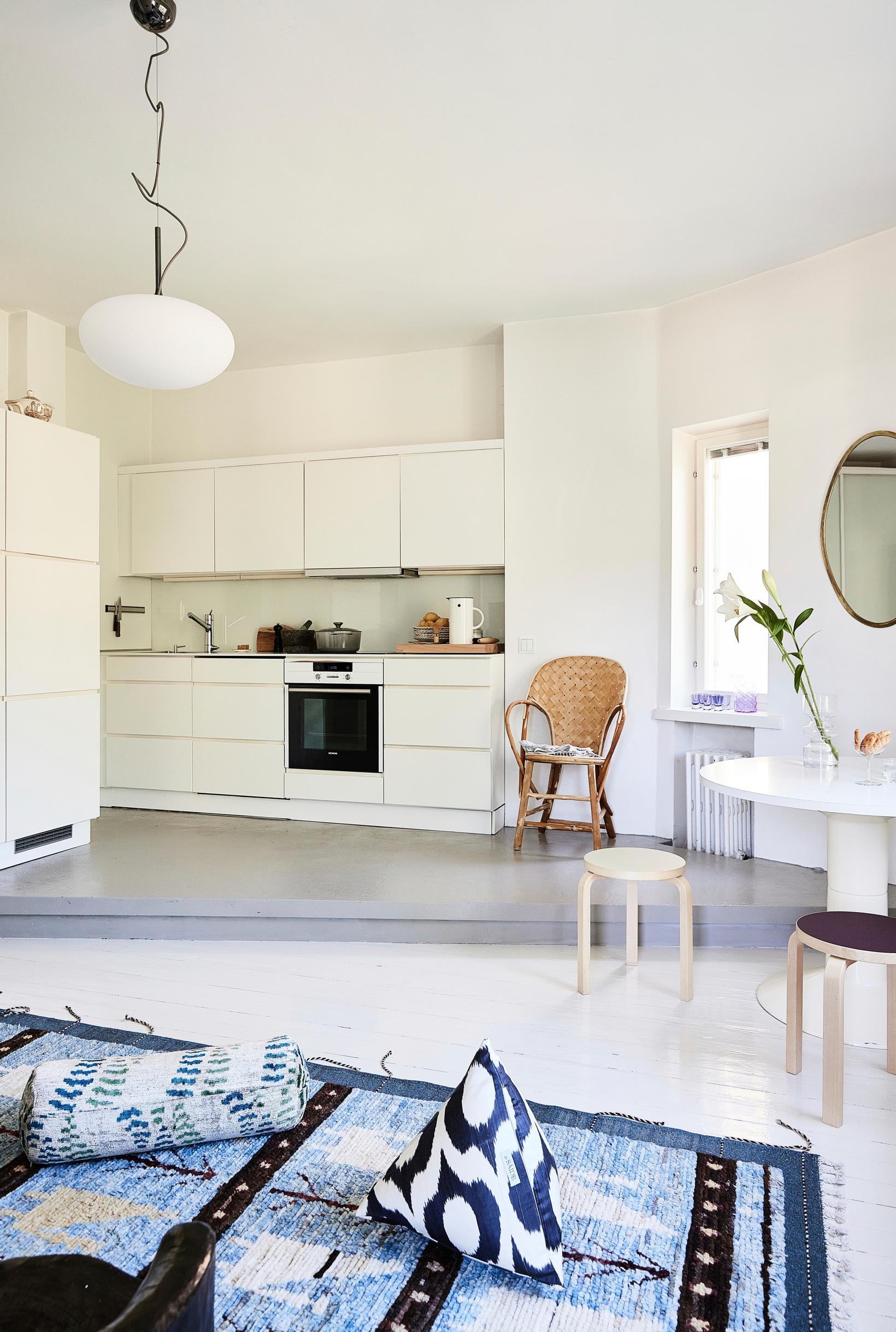 In the living area, the floor transitions from plank to concrete in the triangular kitchen space.