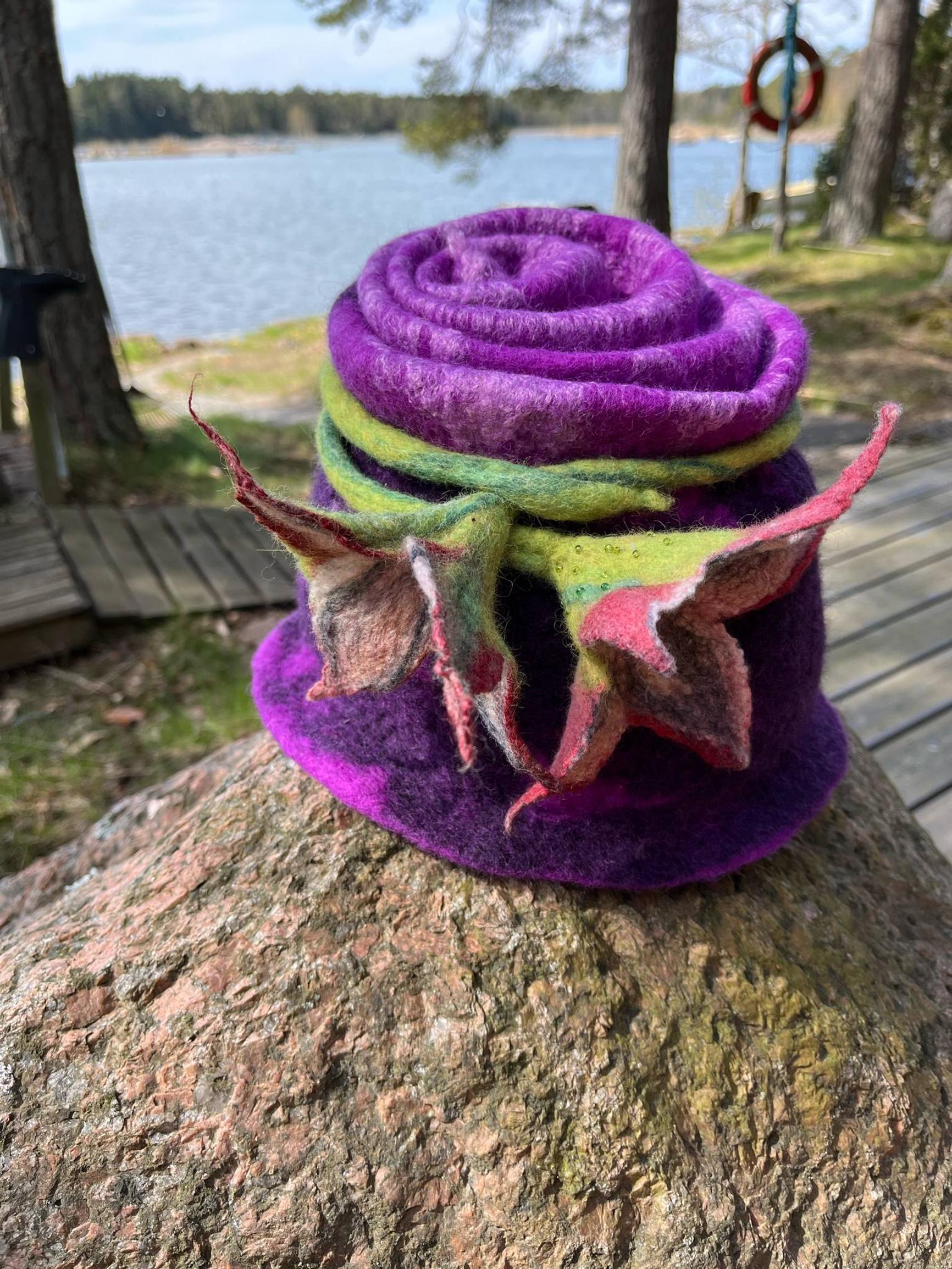 A felted hat adorned with felted flowers.