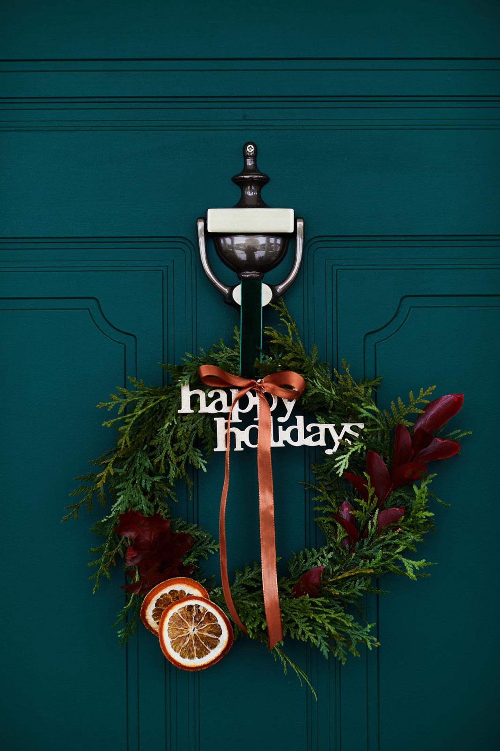 A thuja wreath adorned with dried orange slices.