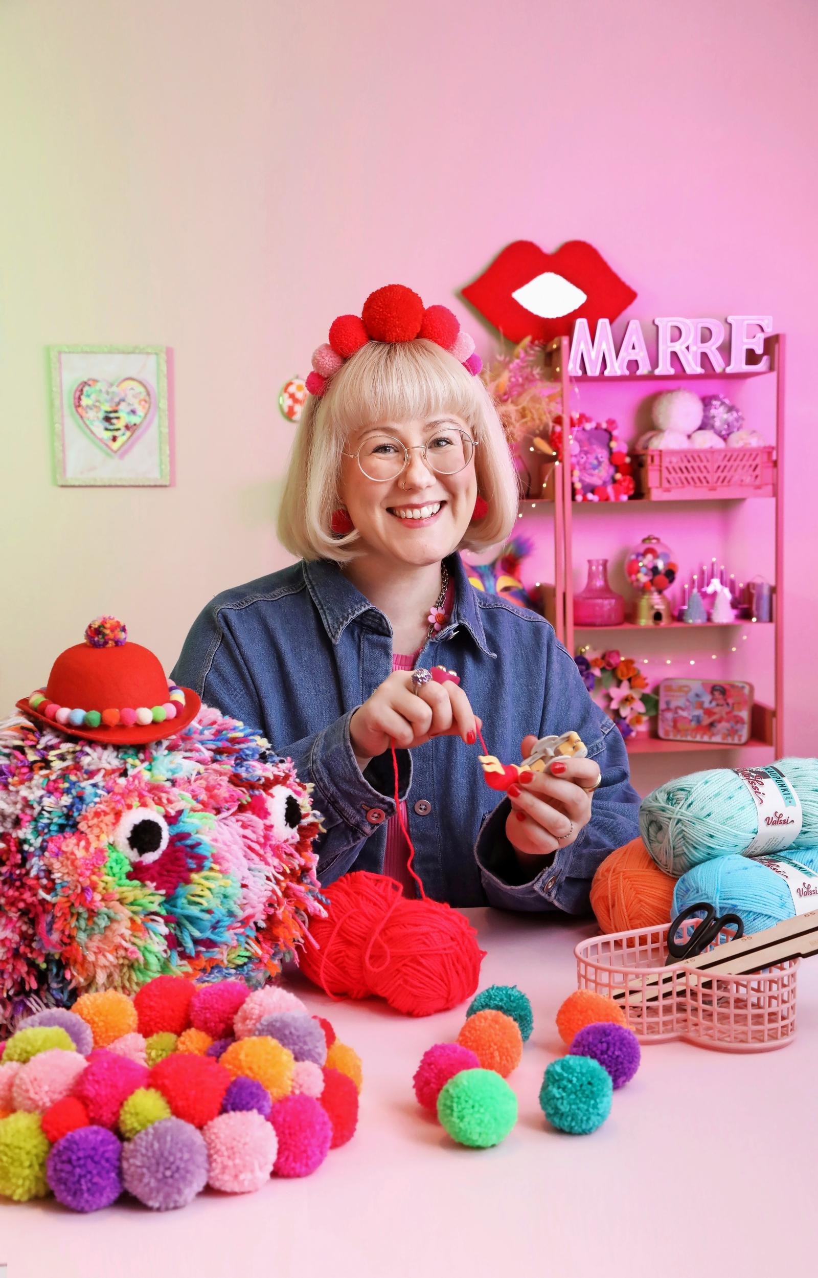 Mari standing next to a giant pom-pom.