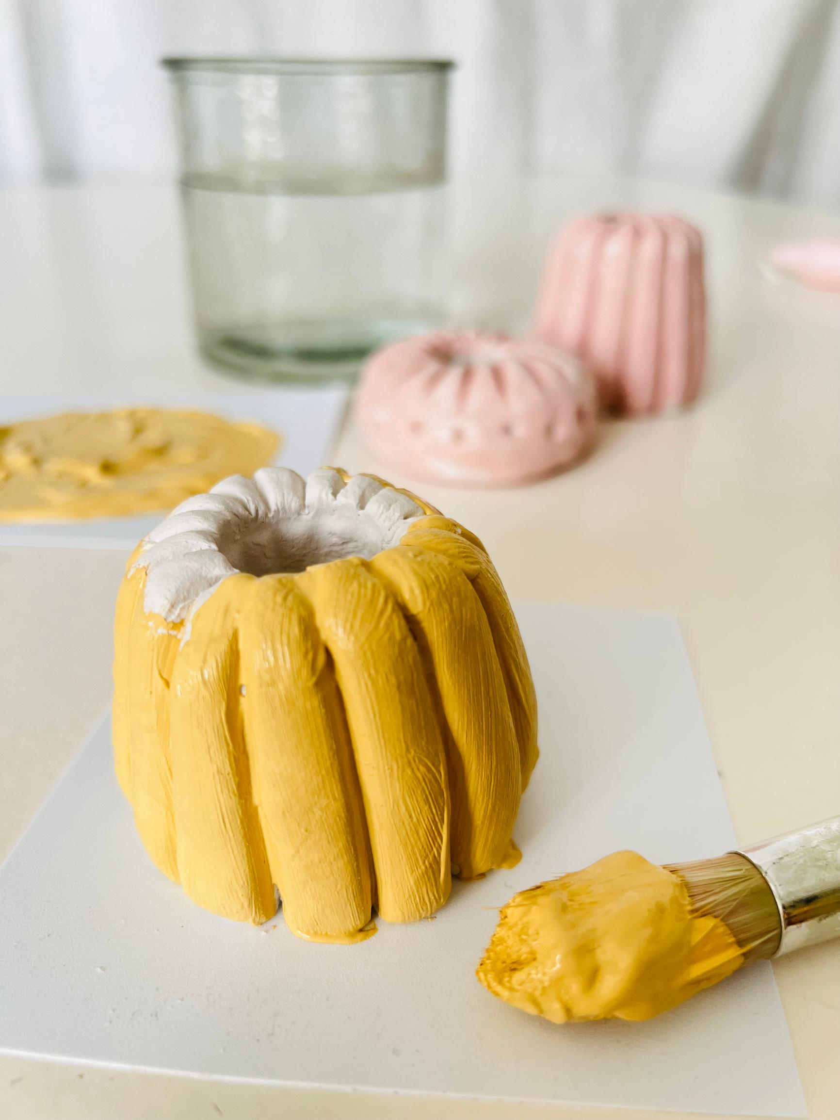 Dried clay candle holders can be painted in various colors.