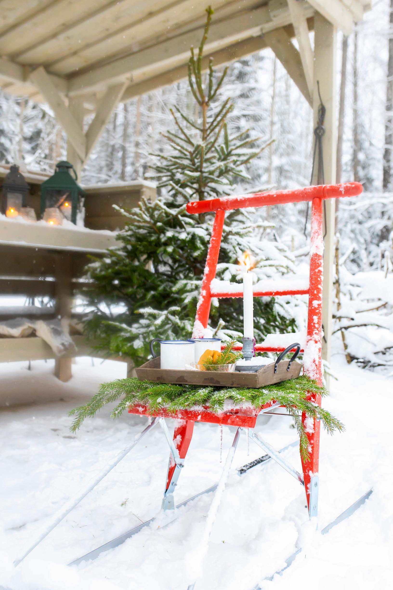 A kicksled with a tray, a Christmas tree, and lanterns in the summer kitchen.