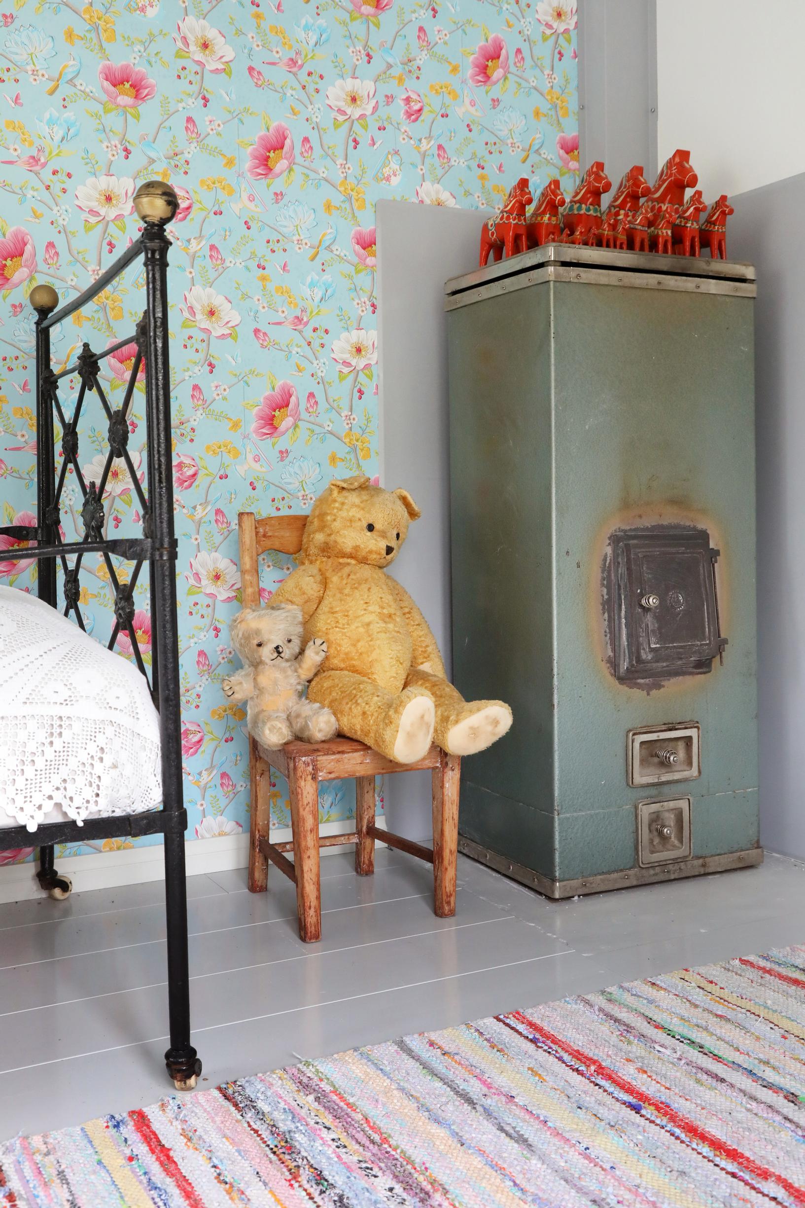 Old fireplace, teddy bear, and rag rug.