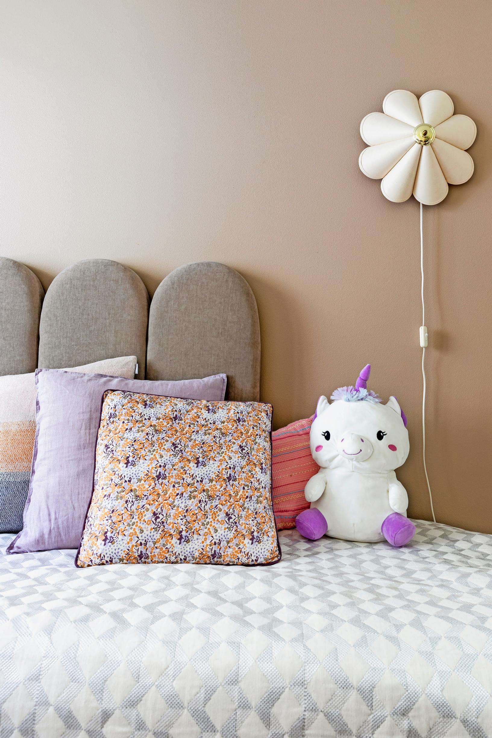 Photo of a headboard and a vintage lamp in a child’s room.