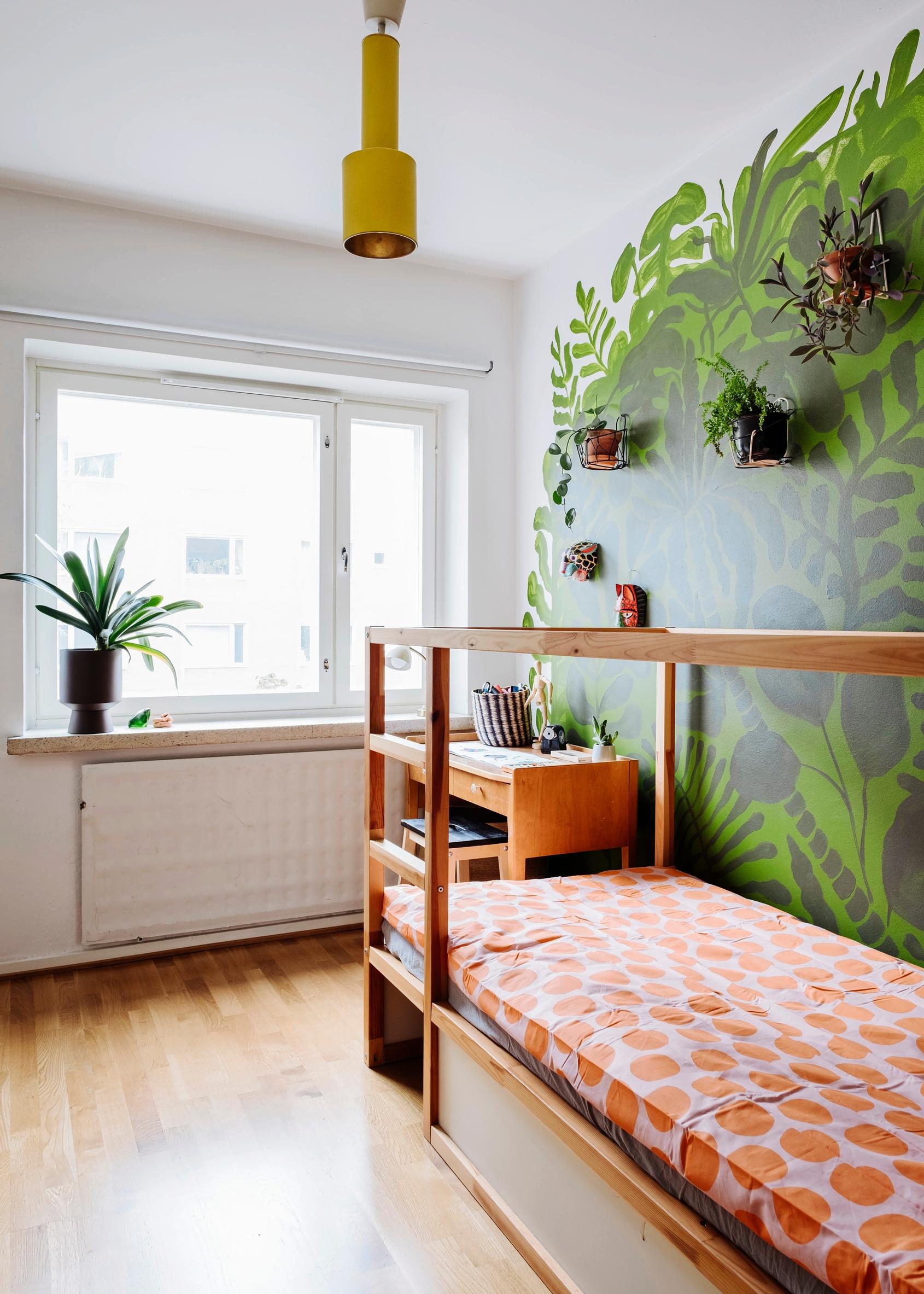 A striking green-toned wall mural in the child’s room