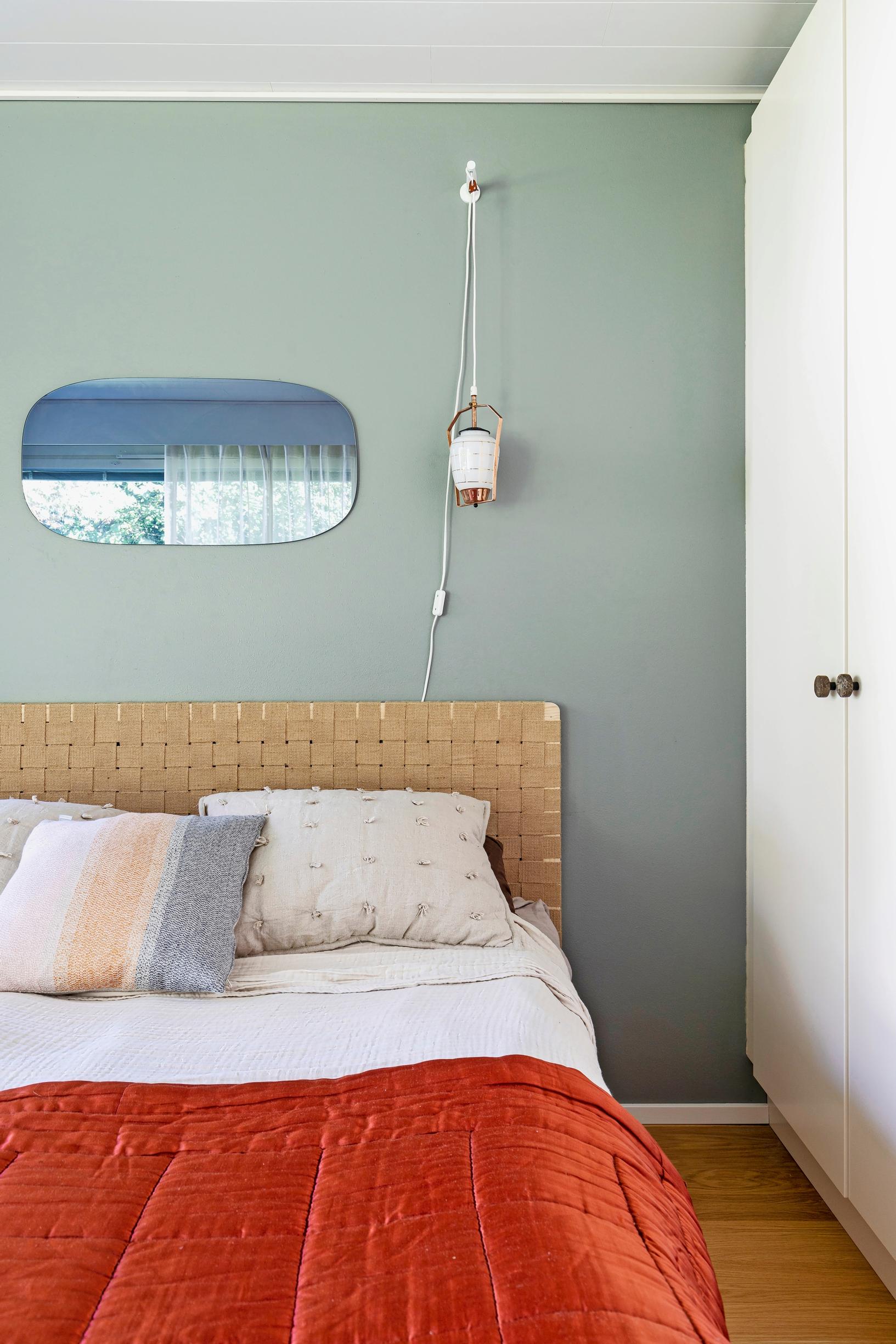 Photo of the bedroom with a saddle belt headboard and a gray wall.