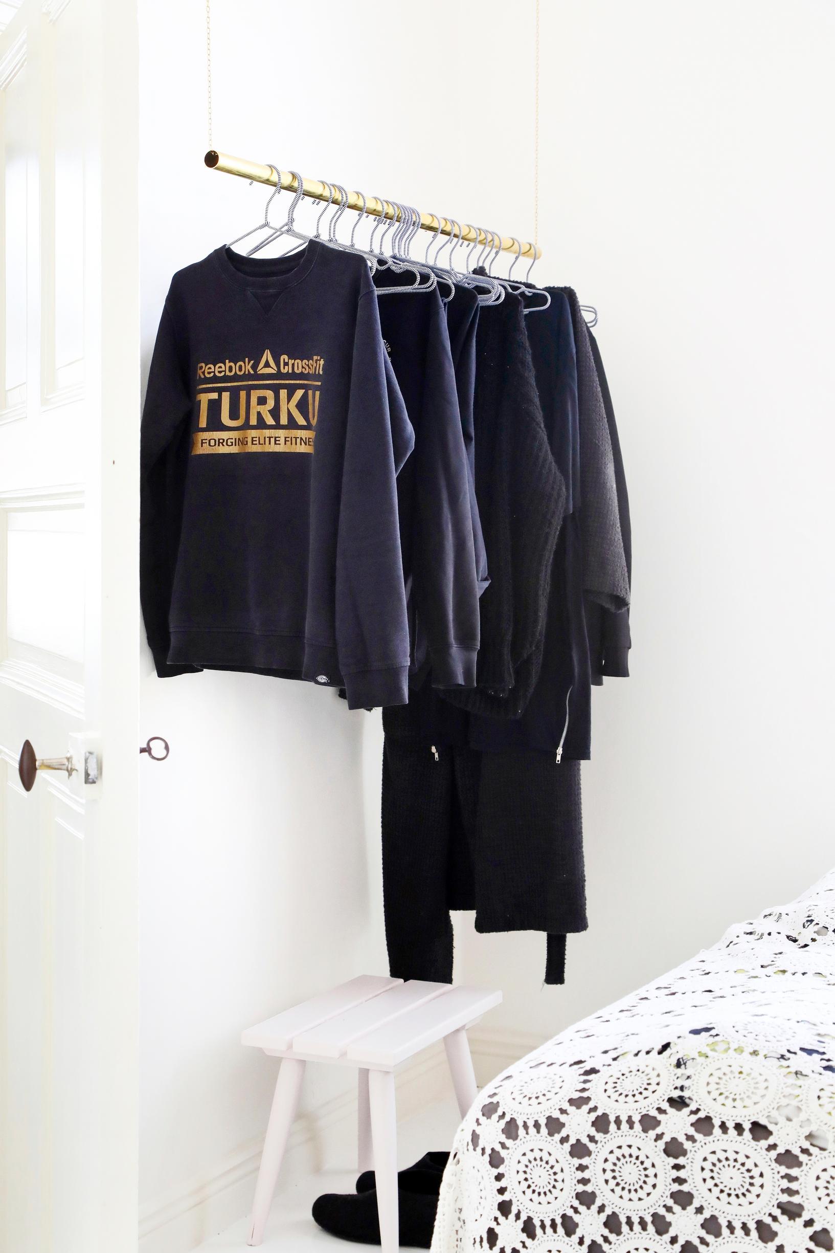An airy clothes rack made from metal pipe and chain