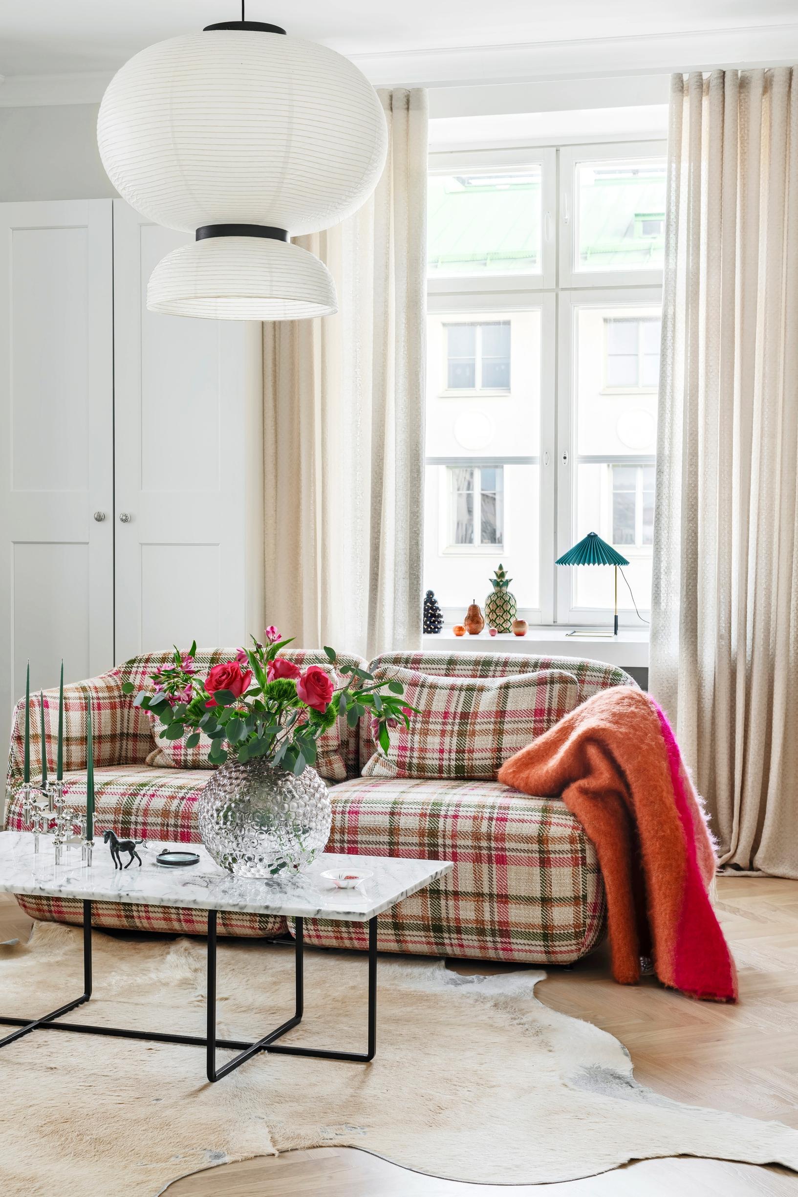 TV room couch with checkered fabric and marble table.